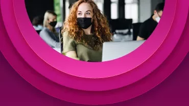 Personas con mascarillas trabajando en oficina.