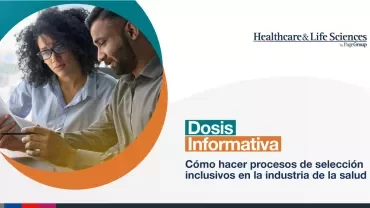 Dos personas revisan documentos en una oficina.