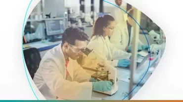 Científicos trabajando en un laboratorio con microscopios y computadoras.