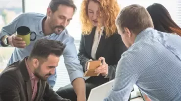 Grupo de personas colaborando en una oficina luminosa.
