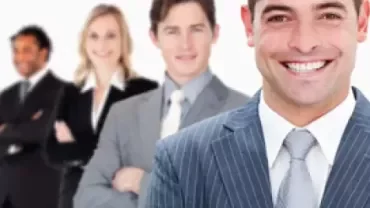 Equipo de personas en trajes formales sonriendo.