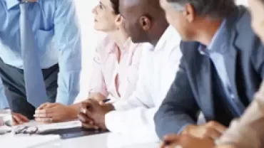 Personas reunidas conversando en una sala de juntas.