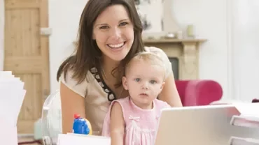 Persona sonriendo junto a un niño en casa.