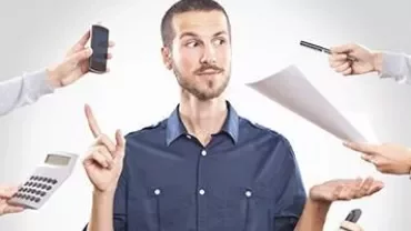 Persona rodeada de manos sosteniendo objetos de trabajo.