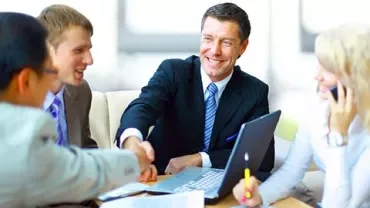 Grupo de personas en una reunión de negocios estrechando manos.