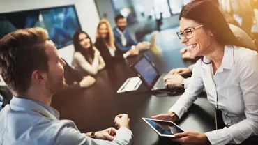 Grupo de personas en una reunión de negocios, con portátiles y tabletas.