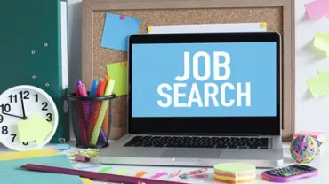 Portátil con pantalla de 'búsqueda de empleo' en un escritorio organizado.