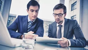 Dos personas revisan un documento en una tablet.