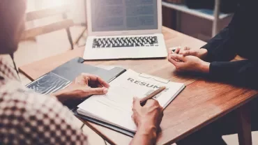 Entrevista de trabajo con currículum sobre la mesa