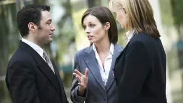 Personas discutiendo en un entorno de oficina.