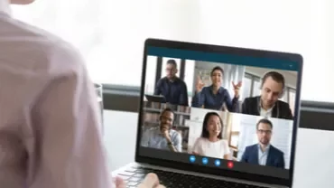 Persona participando en una videollamada con cinco personas en laptop.