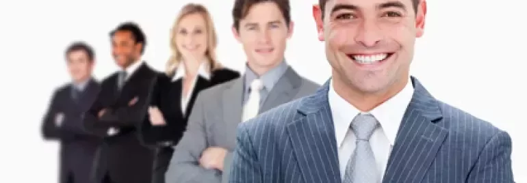 Equipo de personas en trajes formales sonriendo.