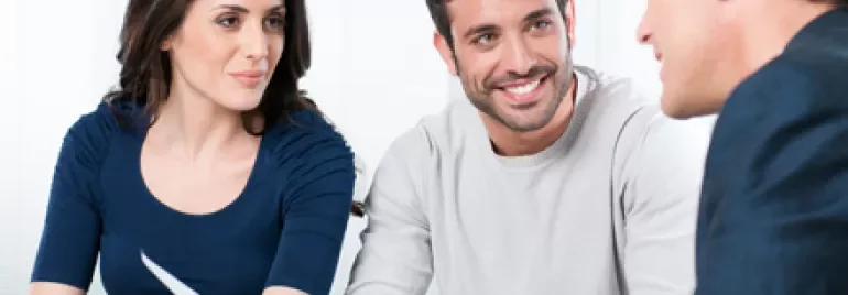 Grupo de personas en una reunión de trabajo, sonriendo y conversando.
