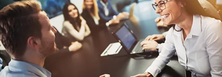 Grupo de personas en una reunión de negocios, con portátiles y tabletas.