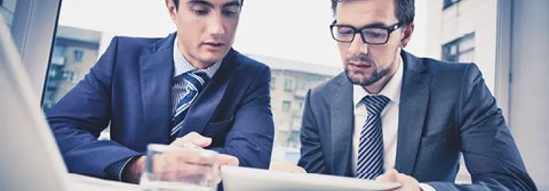 Dos personas revisan un documento en una tablet.