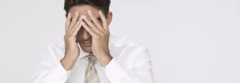 Persona sentada con las manos en el rostro, mostrando preocupación.