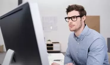 Persona trabajando en una computadora en una oficina.