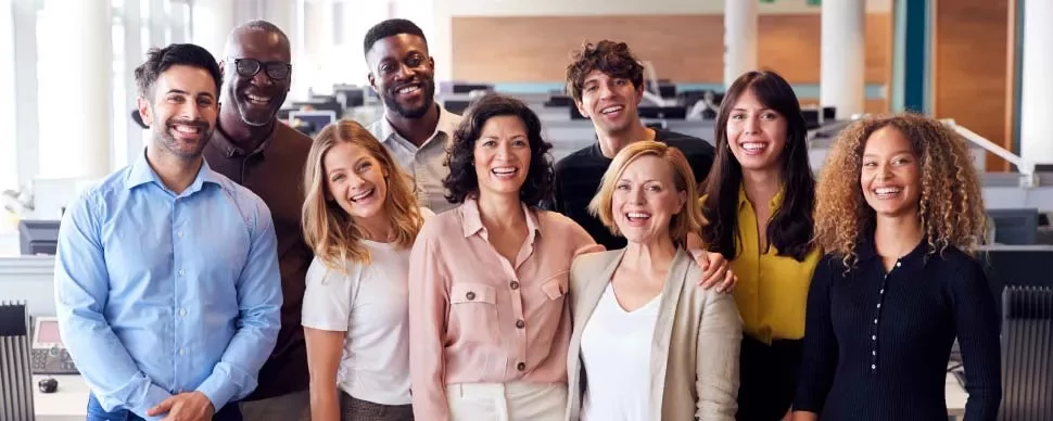 Grupo de personas sonriendo en una oficina moderna.