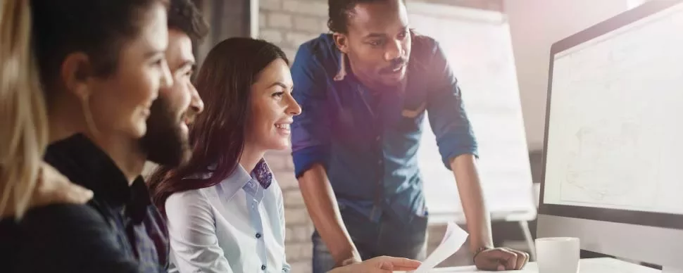 Grupo de personas mirando una pantalla de computadora.