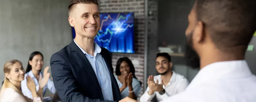 Personas dando un apretón de manos en una reunión de oficina.