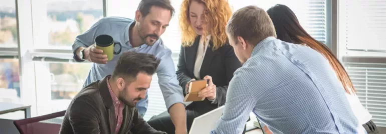 Grupo de personas colaborando en una oficina luminosa.