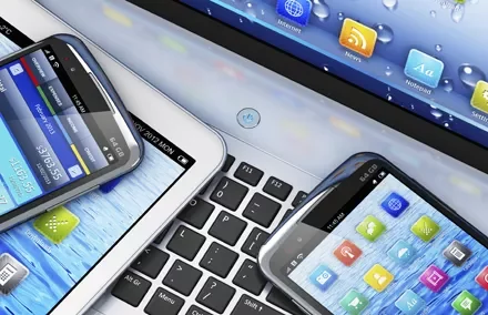 Varios dispositivos móviles sobre un teclado de computadora.