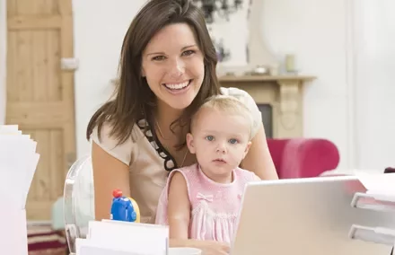 Persona sonriendo junto a un niño en casa.