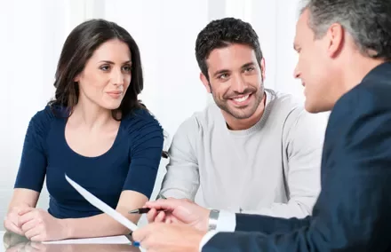 Grupo de personas en una reunión de trabajo, sonriendo y conversando.
