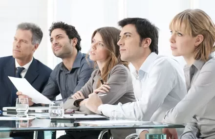 Personas en una reunión de negocios, escuchando atentamente.