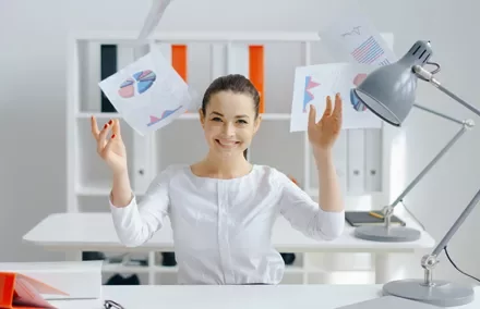 Persona lanzando papeles de gráficos en una oficina moderna.