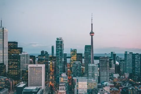 Horizonte urbano al atardecer con torre alta y edificios.