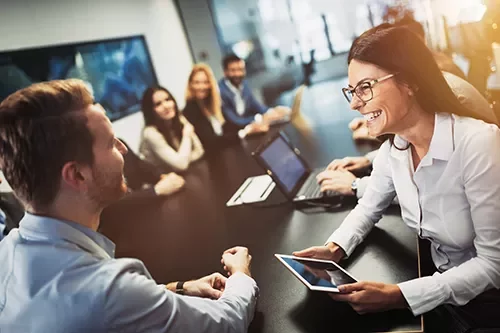 Grupo de personas en una reunión de negocios, con portátiles y tabletas.