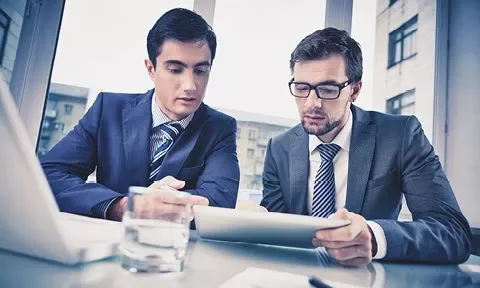 Dos personas revisan un documento en una tablet.